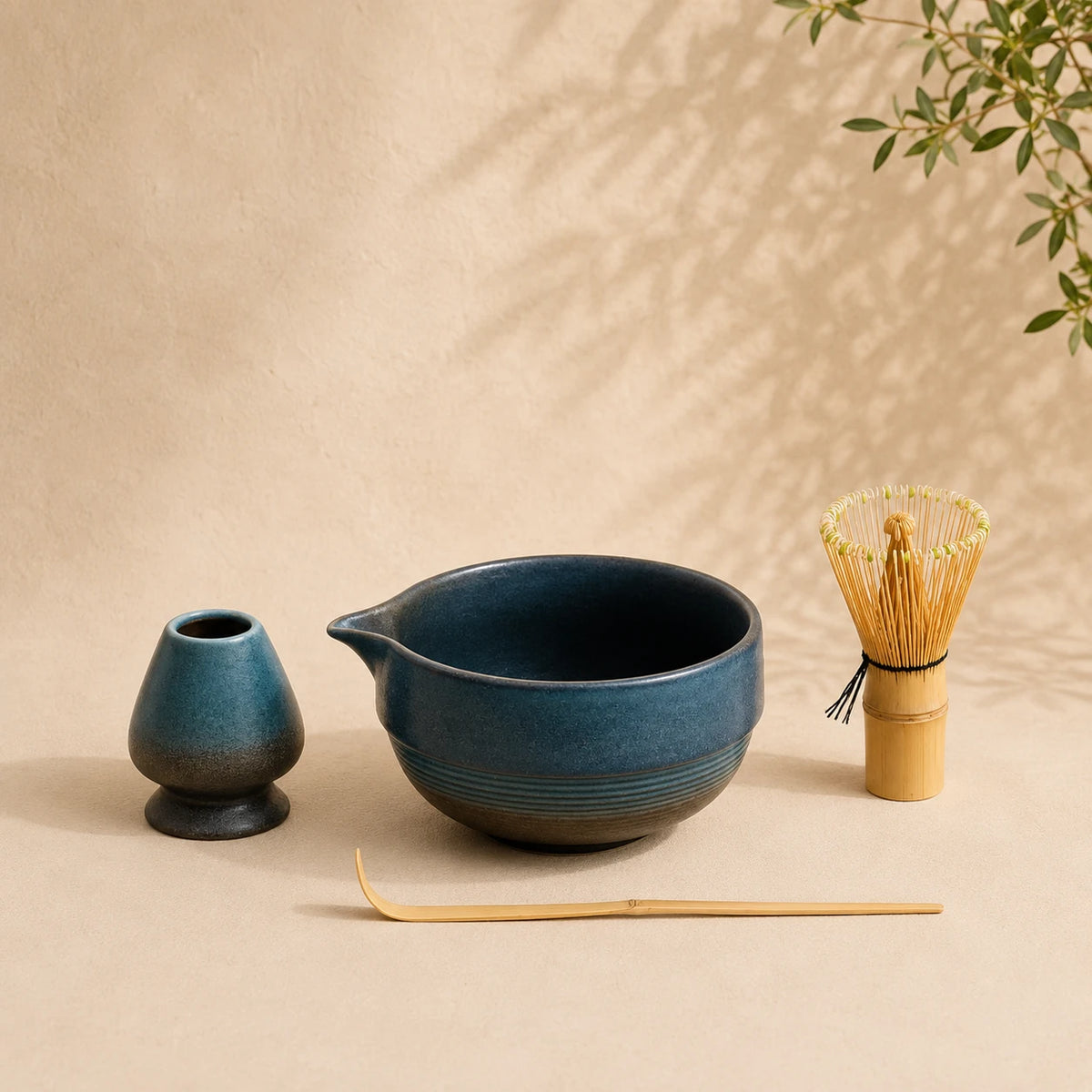 Set matcha Shizuku bleu indigo - bol bicolore avec bec verseur, base grès brut strié et support sur fond beige