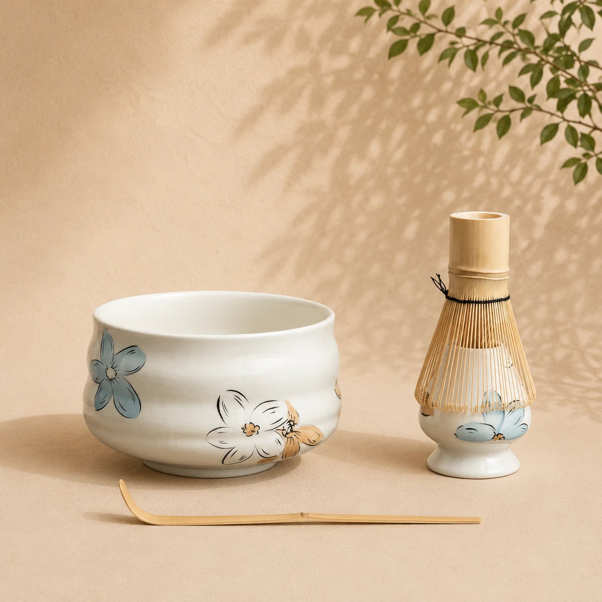 Set matcha Tsubaki blanc nacré fleuri - bol Dehua à motifs floraux bleus et chasen bambou sur fond beige
